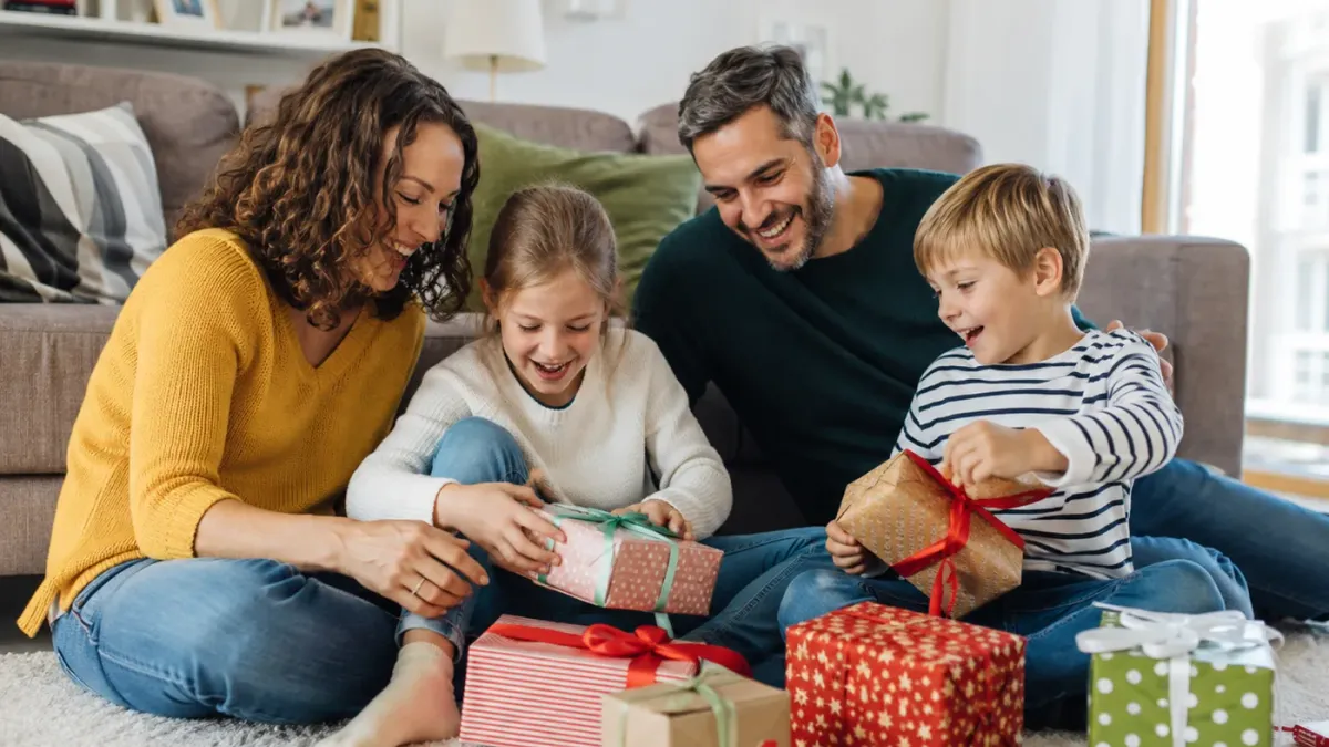 Eine Familie packt gemeinsam ein personalisiertes Fotogeschenk aus