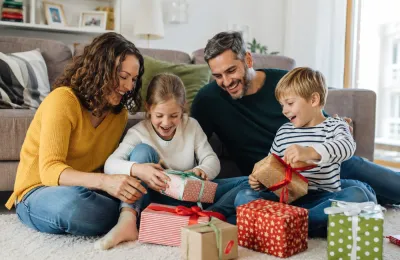 Eine Familie packt gemeinsam ein personalisiertes Fotogeschenk aus