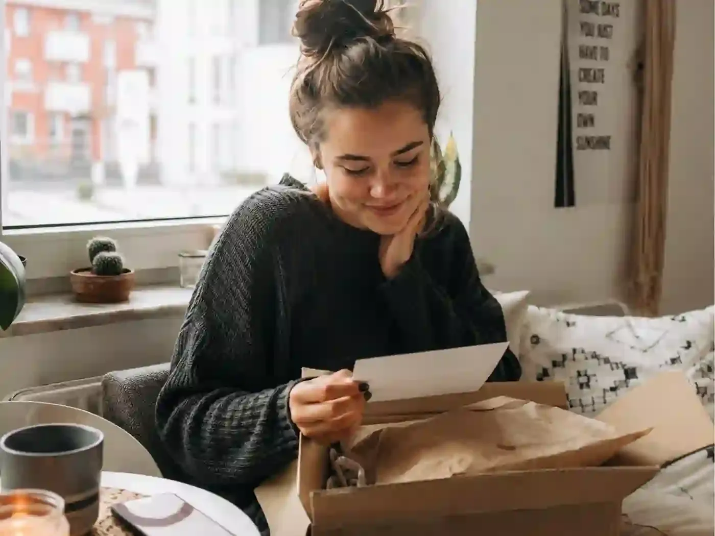 Ein Mann sitzt am Laptop im Videoanruf mit seiner Partnerin, während er ein Geschenk öffnet