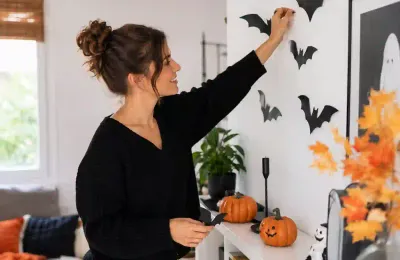 Ein Wohnzimmer mit stimmungsvoller Halloween-Deko, Kürbissen und Fledermaus-Silhouetten