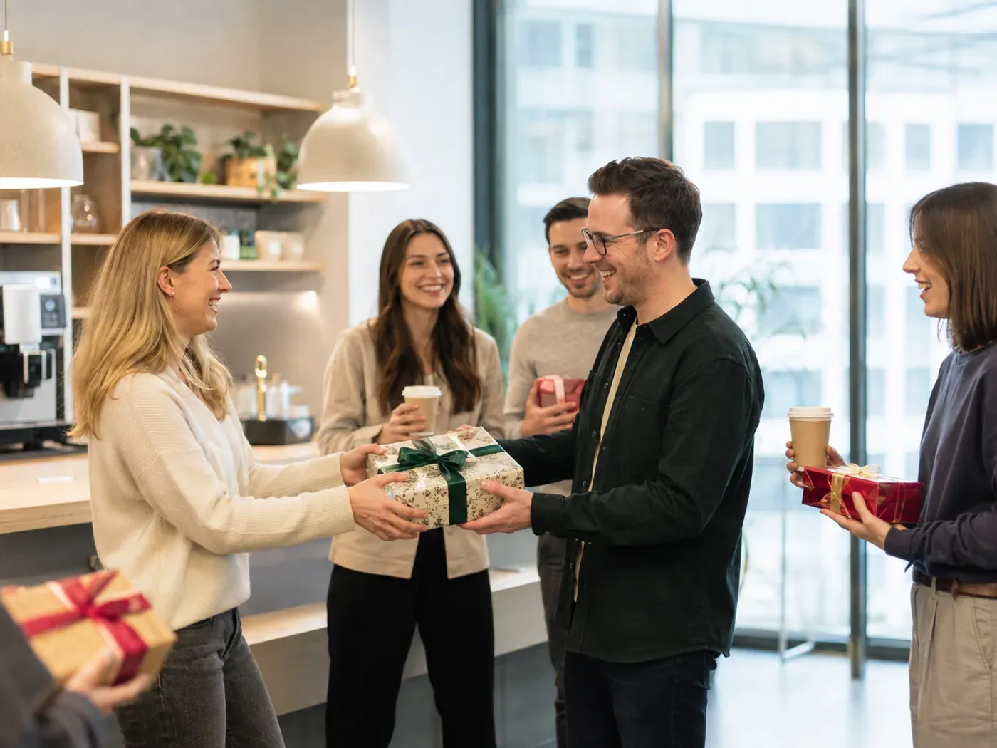 Kolleginnen und Kollegen überreichen sich gegenseitig Geschenke im Büro
